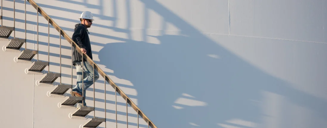 Elevator technician walking down the stairs of a grain elevator.